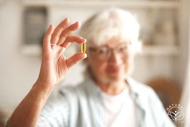 close up shot of elderly woman's hand holding fish oil or omega-3